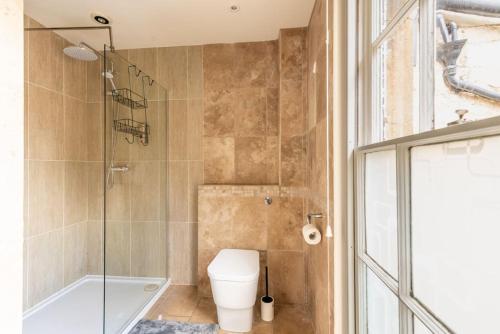a bathroom with a toilet and a glass shower at Look No Further The Stable Block in Beautiful Beaufort House 2 Bedrooms in Bath