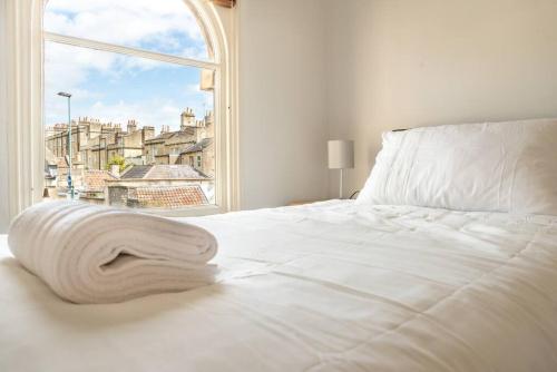 a bedroom with a white bed with a window at Look No Further The Stable Block in Beautiful Beaufort House 2 Bedrooms in Bath
