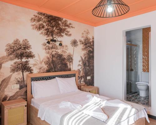 a bedroom with a bed and a wall with trees at Sığacık Gaea Hotel in Izmir