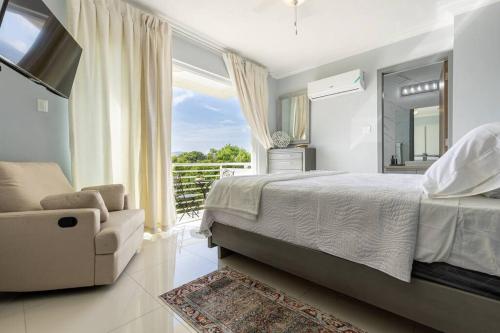 1 dormitorio con 1 cama, 1 silla y 1 ventana en Modern Luxury Apartment in New Kingston, en Kingston