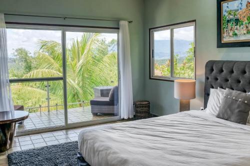 a bedroom with a bed and a large window at Jungle Jewel in Quepos