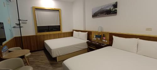a hotel room with two beds and a window at Kanalung Yurakucho House in Taimali