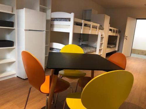 um quarto com uma mesa, cadeiras e beliches em Estelada Boarding Houses em Munique