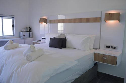 een slaapkamer met een groot wit bed met witte kussens bij DreamSleep in East London