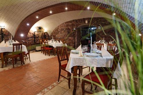 ein Restaurant mit Tischen und Stühlen in einem Zimmer in der Unterkunft Hotel Rubin*** in Gheorgheni