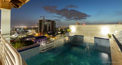 una piscina en la parte superior de un edificio con ciudad en Modern Luxury Apartment in New Kingston, en Kingston