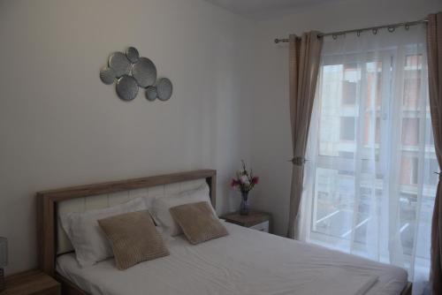 普洛耶什蒂的住宿－Real Resort-Apartament cu 2 camere in cartier rezidential，一间卧室配有一张带窗户和时钟的床