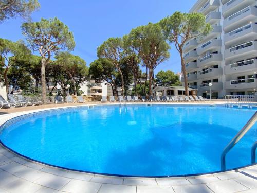 a large swimming pool with chairs and trees at Rentalmar Blue Beach & Pool in Salou