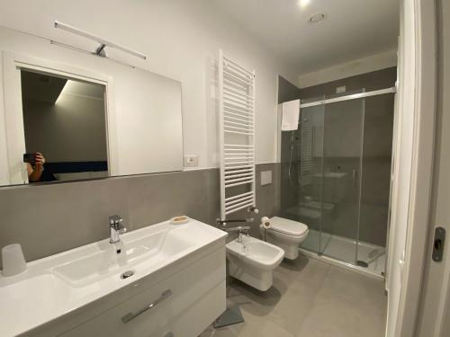 een badkamer met een wastafel, een toilet en een spiegel bij LA DIMORA DEL FALEGNAME in Matera