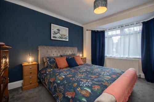 um quarto com uma cama com paredes azuis e uma janela em Cosy home from home em Bournemouth