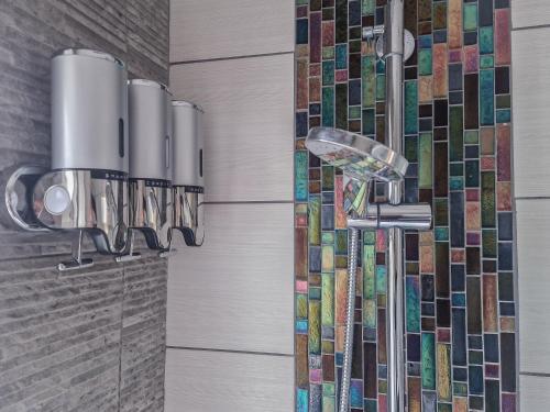 y baño con ducha y pared de mosaico. en Cosy home from home, en Bournemouth