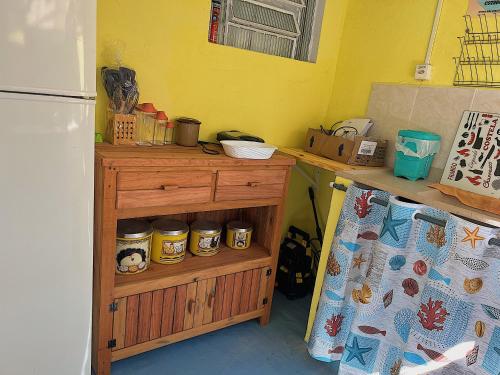 a kitchen with a refrigerator and a counter with jars at Hostel Coraticum in Ubatuba