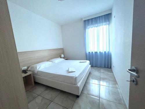 a bedroom with a white bed and a window at Hotel Park in Rossano
