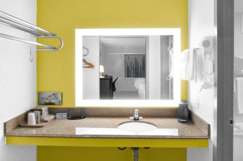 a bathroom with a sink and a mirror at Econo Lodge in Carlsbad