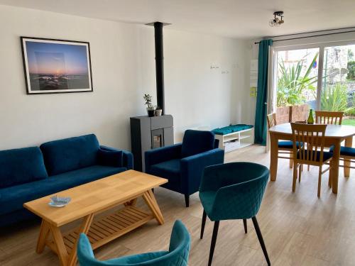 - un salon avec un canapé bleu, des chaises et une table dans l'établissement Rive droite bord de plage, à Réville