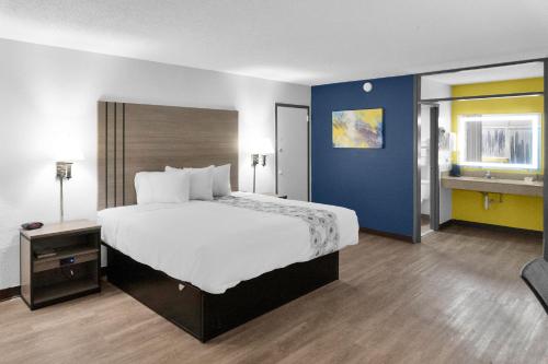 1 dormitorio con 1 cama grande y pared azul en Econo Lodge, en Carlsbad