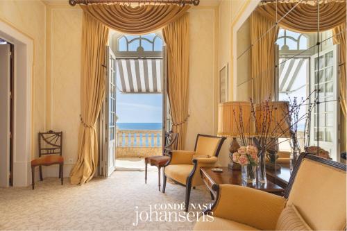 a living room with yellow curtains and a table and chairs at Estoril Vintage Hotel in Estoril