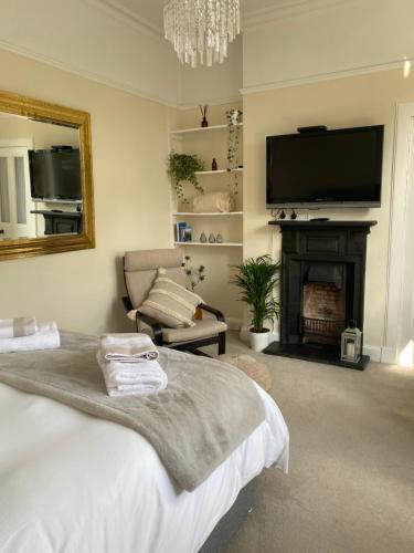 1 dormitorio con 1 cama, chimenea y TV en Tranquil Haven Murrayfield, en Edimburgo