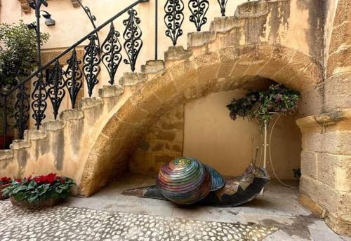 a large vase sitting on the ground under a staircase at Rinaldo Holiday Home in Sambuca di Sicilia