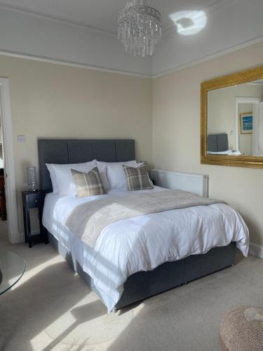 a bedroom with a large bed and a mirror at Tranquil Haven Murrayfield in Edinburgh