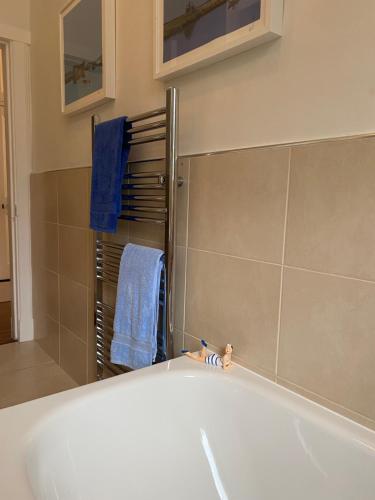 a bathroom with a tub and a towel rack at Tranquil Haven Murrayfield in Edinburgh
