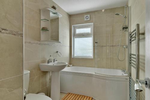 a bathroom with a tub and a sink and a toilet at Finest Retreats - Seacroft in Torpoint