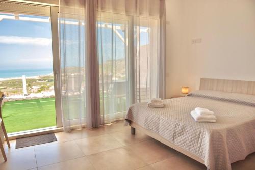 a bedroom with a bed and a large window at Villa Quantum in Siculiana Marina