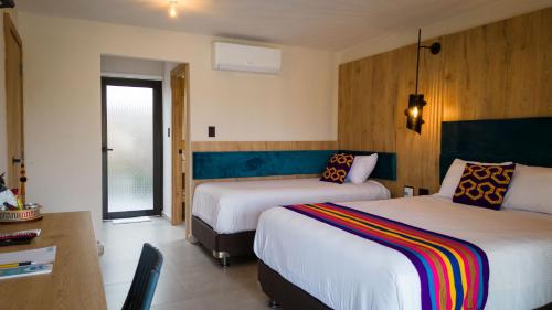 a hotel room with two beds and a desk at GUAJIRA CASA DEL MAR in Ríohacha