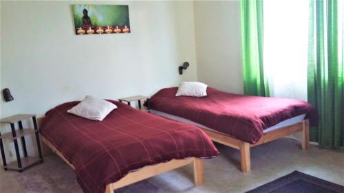 2 camas con mantas rojas en una habitación en Neuss-Nord, en Neuss