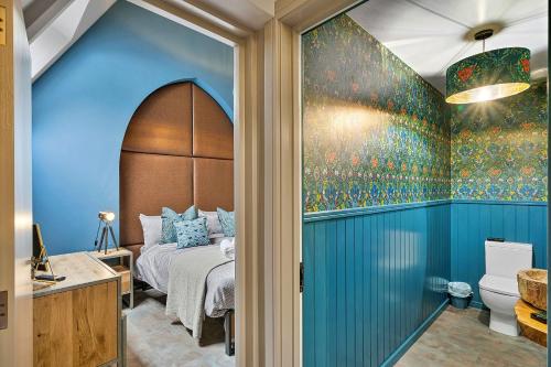 Un dormitorio con una cama y una pared azul. en Finest Retreats - Towan House, en Newquay