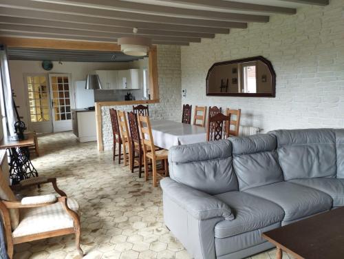 uma sala de estar com um sofá e uma sala de jantar em AU BON CAUCHOIS em Anglesqueville-lʼ Esneval