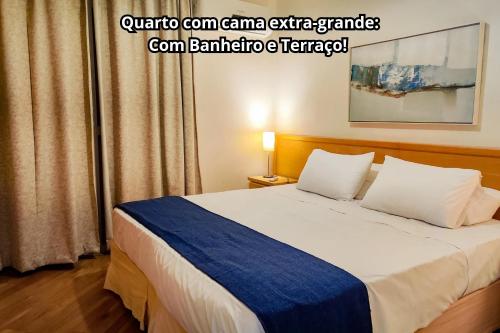 1 dormitorio con 1 cama con manta azul y blanca en Residencial Bella Vista Suites en São Paulo