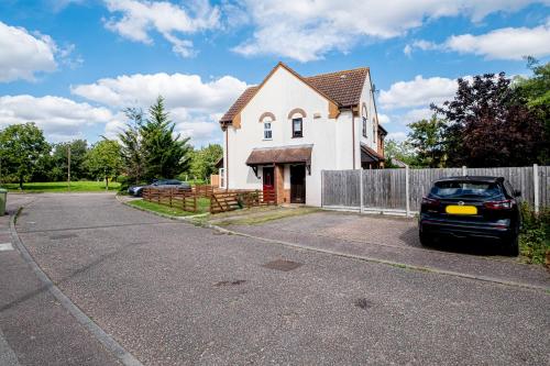 um carro estacionado em frente a uma casa em Wheatley House em Milton Keynes