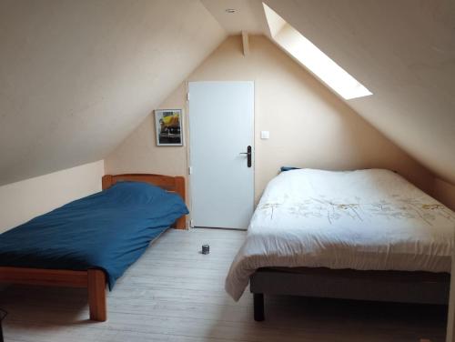 um quarto no sótão com 2 camas e uma porta em AU BON CAUCHOIS em Anglesqueville-lʼ Esneval