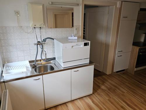 a small kitchen with a sink and a microwave at B76, Lauterach, Vorarlberg Apartments in Lauterach