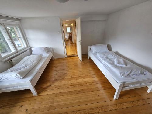 two beds in a room with wooden floors at B76, Lauterach, Vorarlberg Apartments in Lauterach