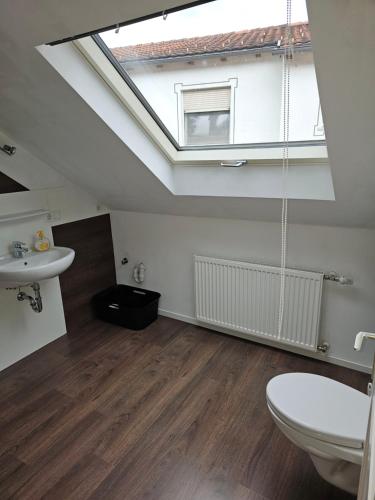 a bathroom with a toilet and a sink and a skylight at VlbgApart Lauterach Bu76 in Lauterach