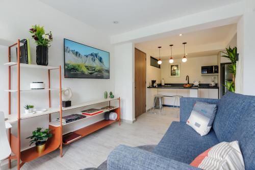 a living room with a blue couch and a kitchen at Choapan 28 - Lux Apartments in Condesa in Mexico City