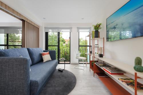 un soggiorno con divano blu e TV di Choapan 28 - Lux Apartments in Condesa a Città del Messico