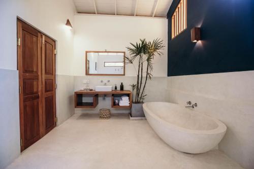 een badkamer met een groot bad en een wastafel bij Kara in Ahangama