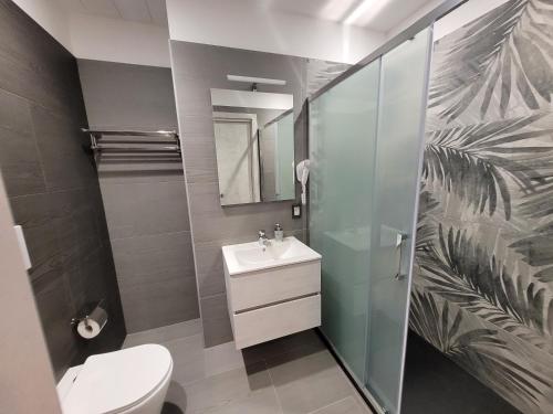 uma casa de banho com um WC, um lavatório e um espelho. em SP Rooms em Isola delle Femmine