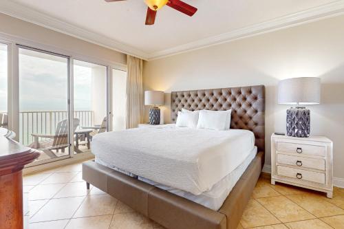 a bedroom with a large bed and a balcony at TOPS'L Tides III in Destin