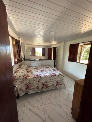 a bedroom with a bed with a floral bedspread at Flat Recanto da Natureza in Cabo de Santo Agostinho