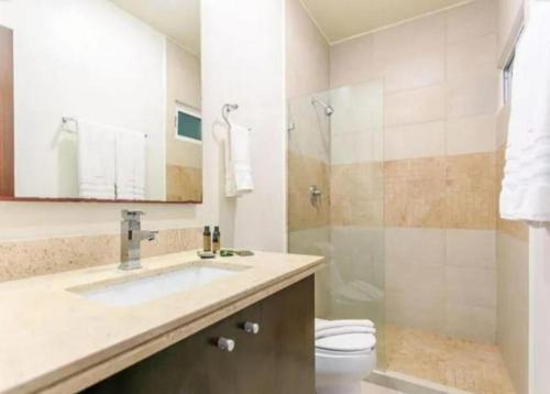 een badkamer met een wastafel, een toilet en een douche bij Caribe Grand Dream in Playa del Carmen