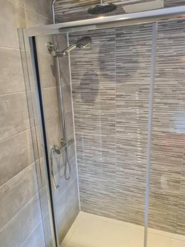a shower with a glass door in a bathroom at MASSIVE 4 Bed home walking distance to the City lights, perfect for business trips in Belfast