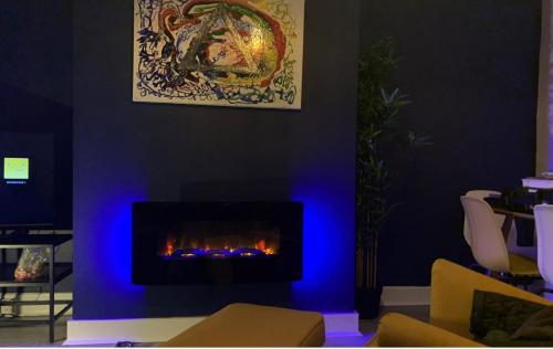 un salon avec une cheminée et un éclairage bleu dans l'établissement Shotley Bridge - Large Stylish 3 Bedroom Apartment, à Consett