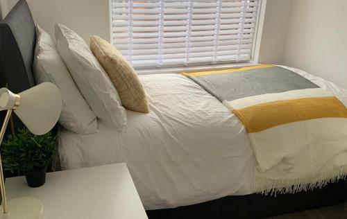 - une chambre avec un lit blanc avec des oreillers et une fenêtre dans l'établissement Shotley Bridge - Large Stylish 3 Bedroom Apartment, à Consett