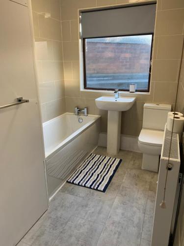 La salle de bains est pourvue d'une baignoire, d'un lavabo et de toilettes. dans l'établissement Shotley Bridge - Large Stylish 3 Bedroom Apartment, à Consett