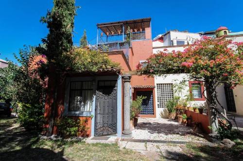 a house with a door and a tree in front of it at Home in San Miguel de Allende. Casita de La Aldea in San Miguel de Allende