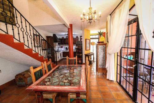 a dining room with a table and a staircase at Home in San Miguel de Allende. Casita de La Aldea in San Miguel de Allende